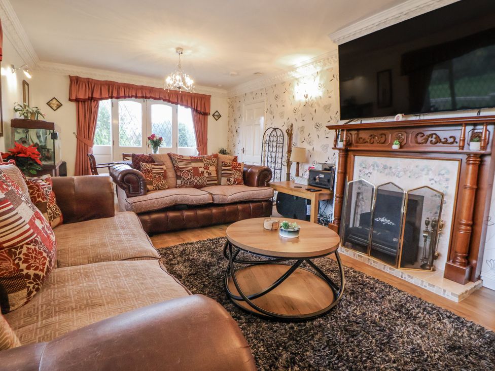 A living room with a sofa and fireplace at Freshwinds in Market Drayton