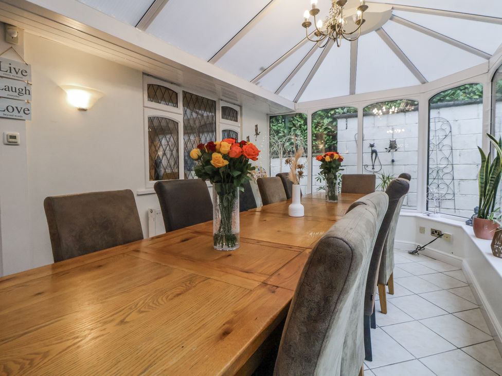 A dining table with chairs and flowers at Freshwinds in Market Drayton