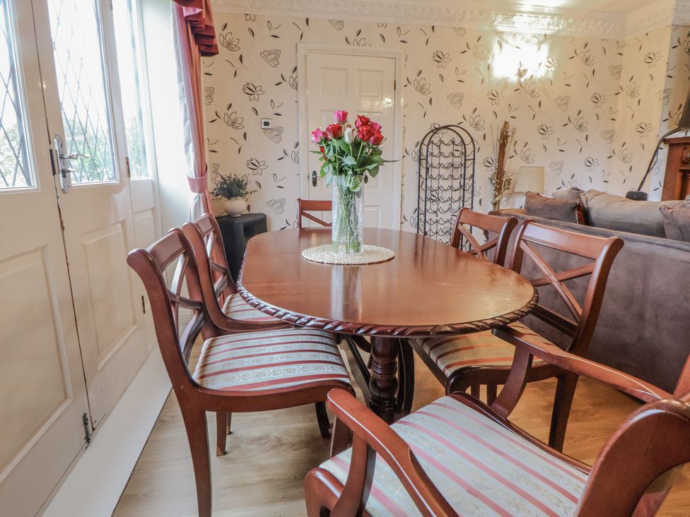A dining room with a round table and chairs at Freshwinds in Market Drayton