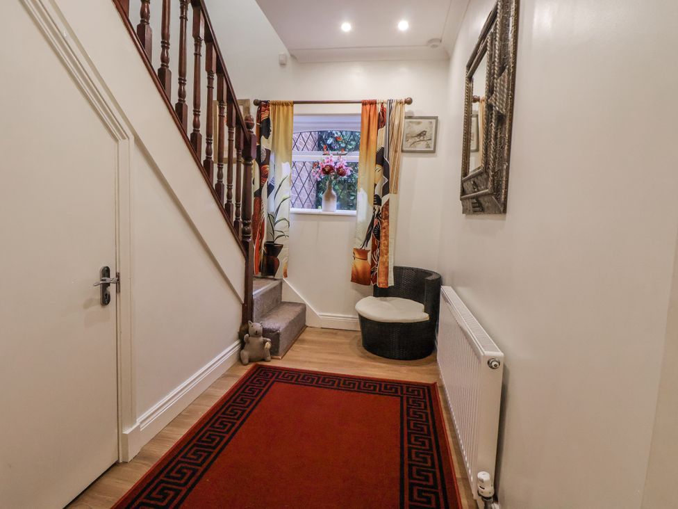 A hallway with stairs and a window at Freshwinds in Market Drayton