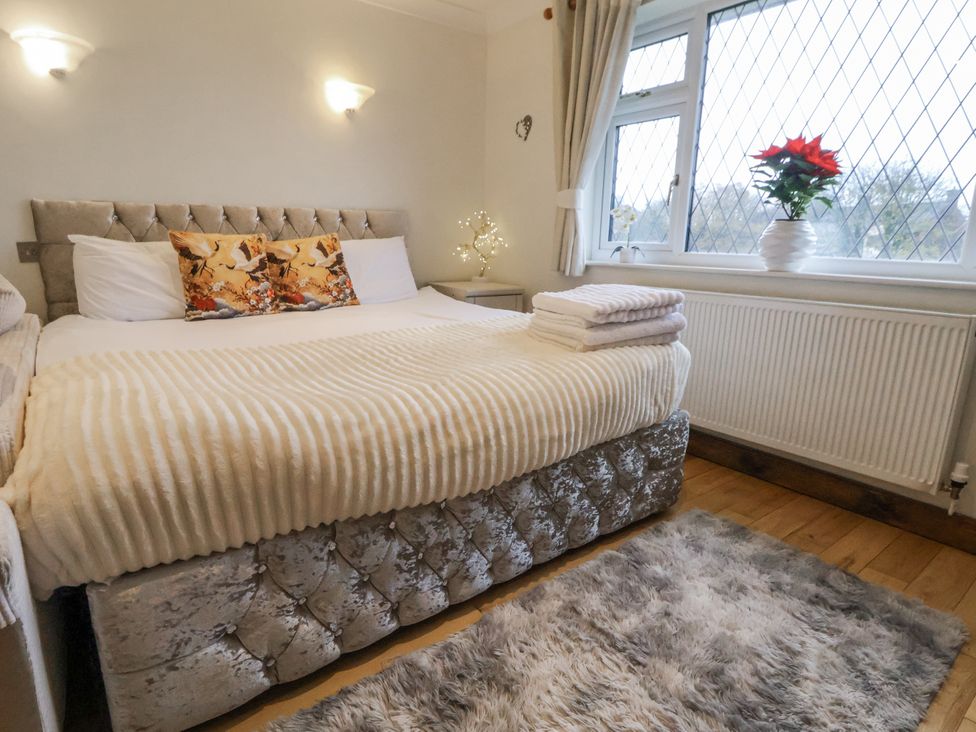 A bedroom with a large bed and window at Freshwinds Market Drayton