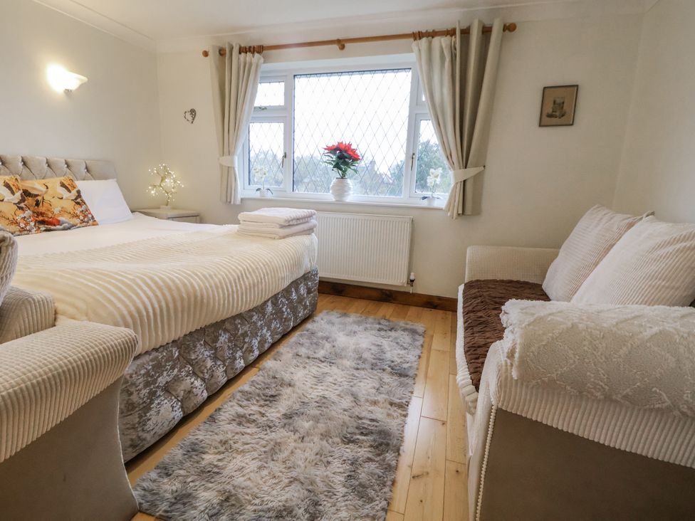 A bedroom with a bed and sofa at Freshwinds Market Drayton