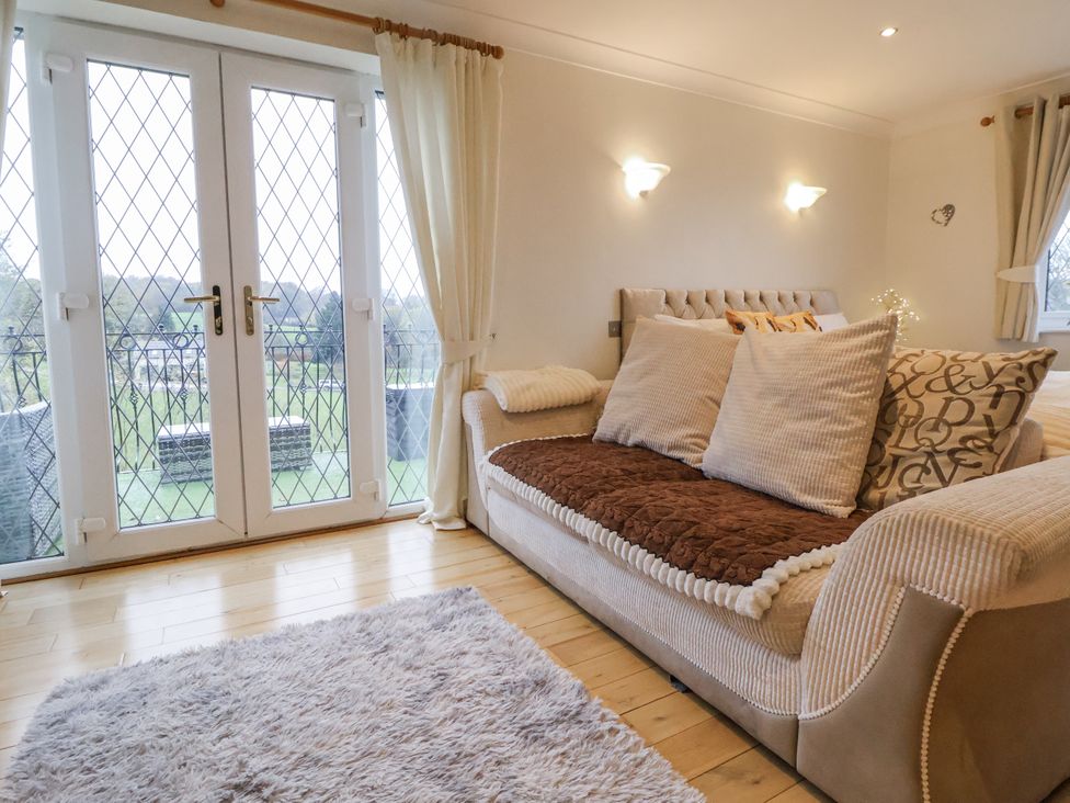 A living room with a sofa and French doors at Freshwinds Market Drayton