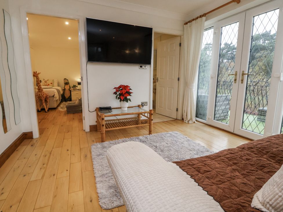 A living room with a television and sliding door leading outside at Freshwinds in Market Drayton