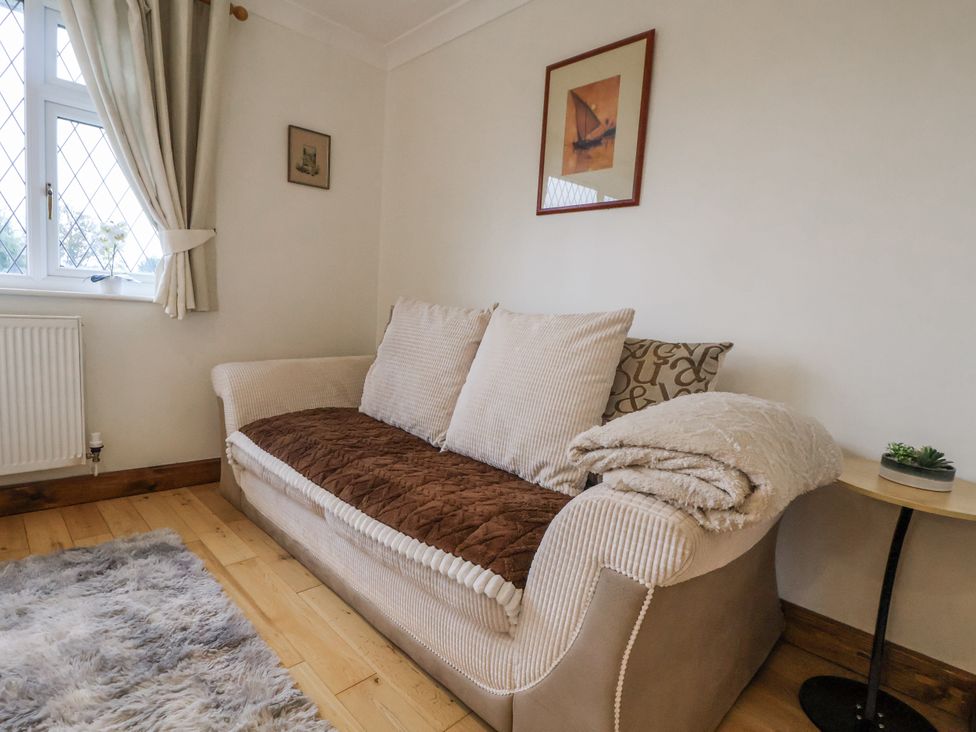 A living room with a sofa and cushions at Freshwinds Market Drayton