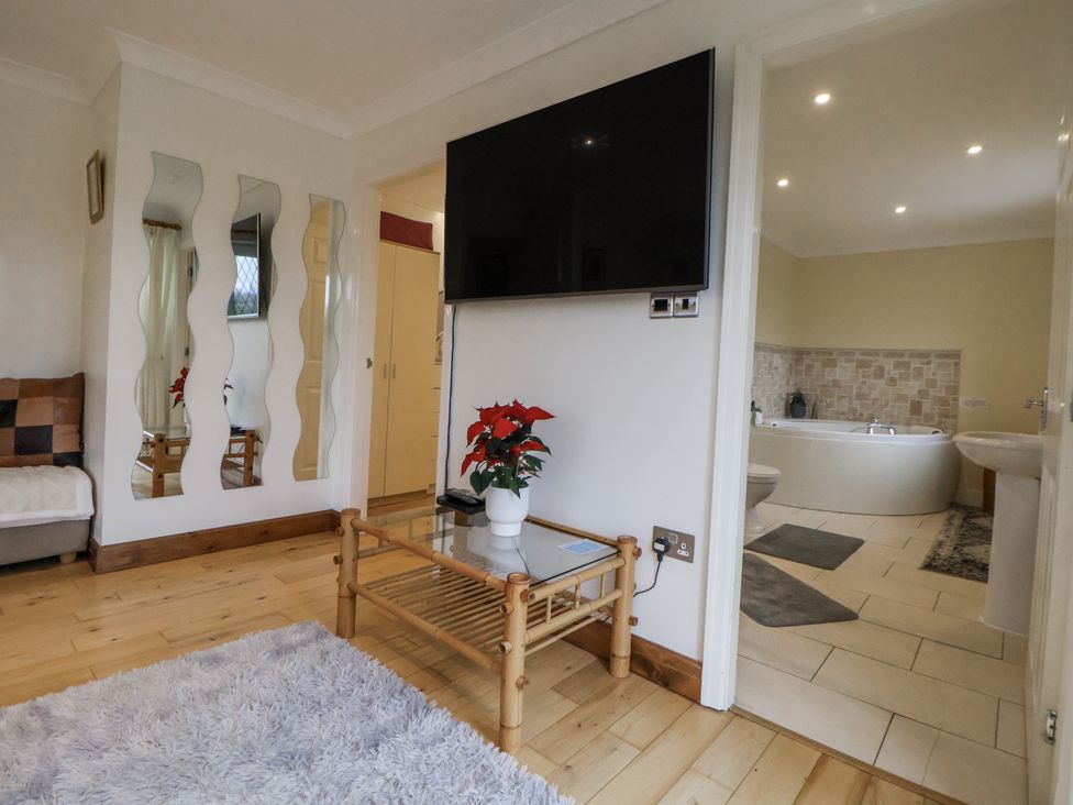 A living room with a television and a view of the bathroom at Freshwinds in Market Drayton