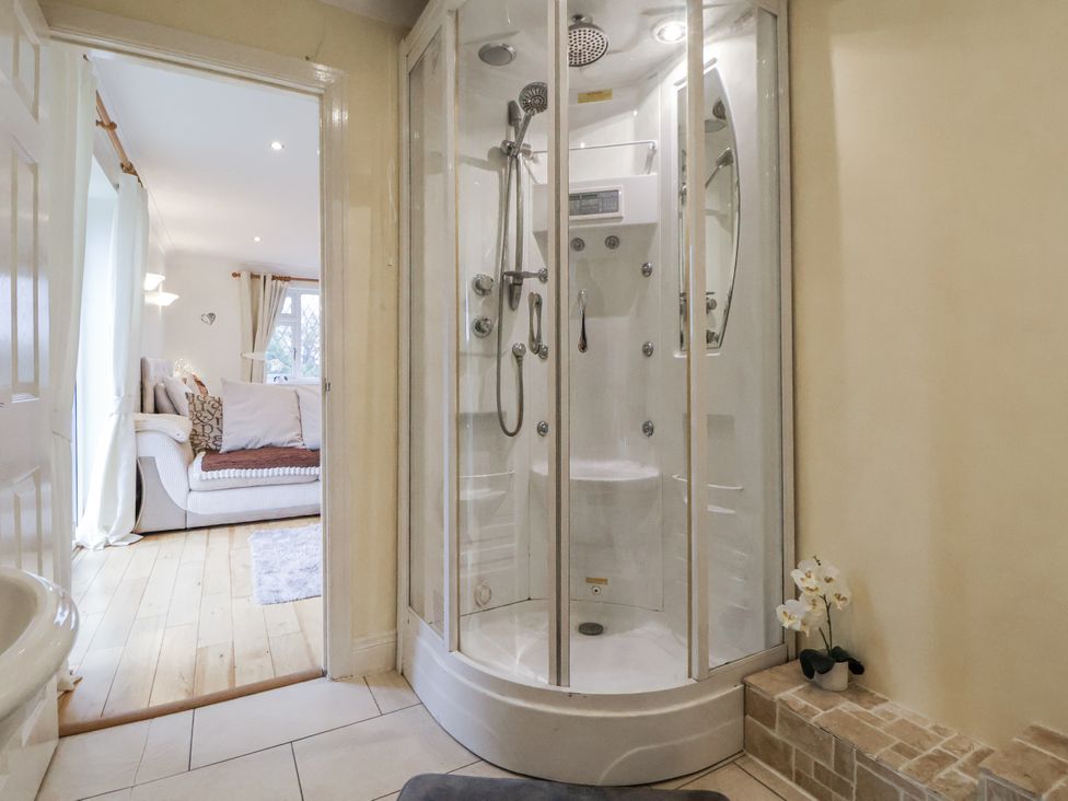 A bathroom with a shower and view to a living room at Freshwinds in Market Drayton