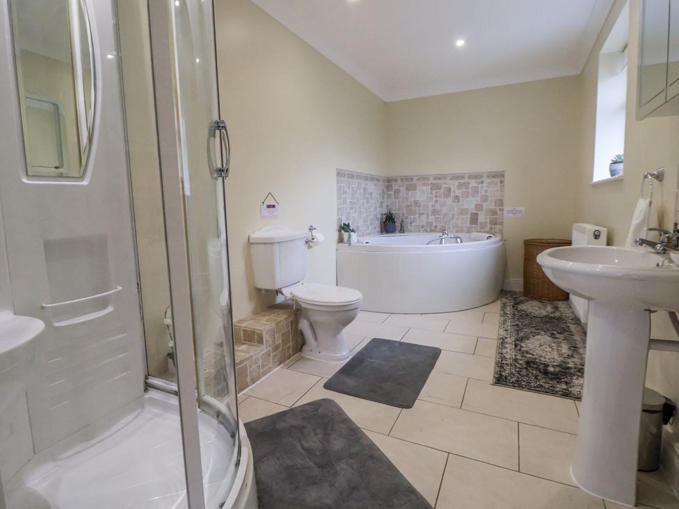 A bathroom with a shower, bathtub, and sink at Freshwinds in Market Drayton