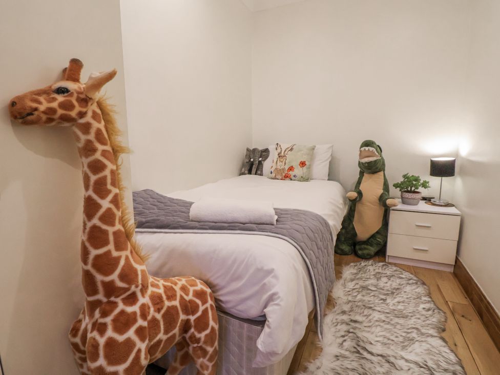 A bedroom with a bed and stuffed animals at Freshwinds in Market Drayton