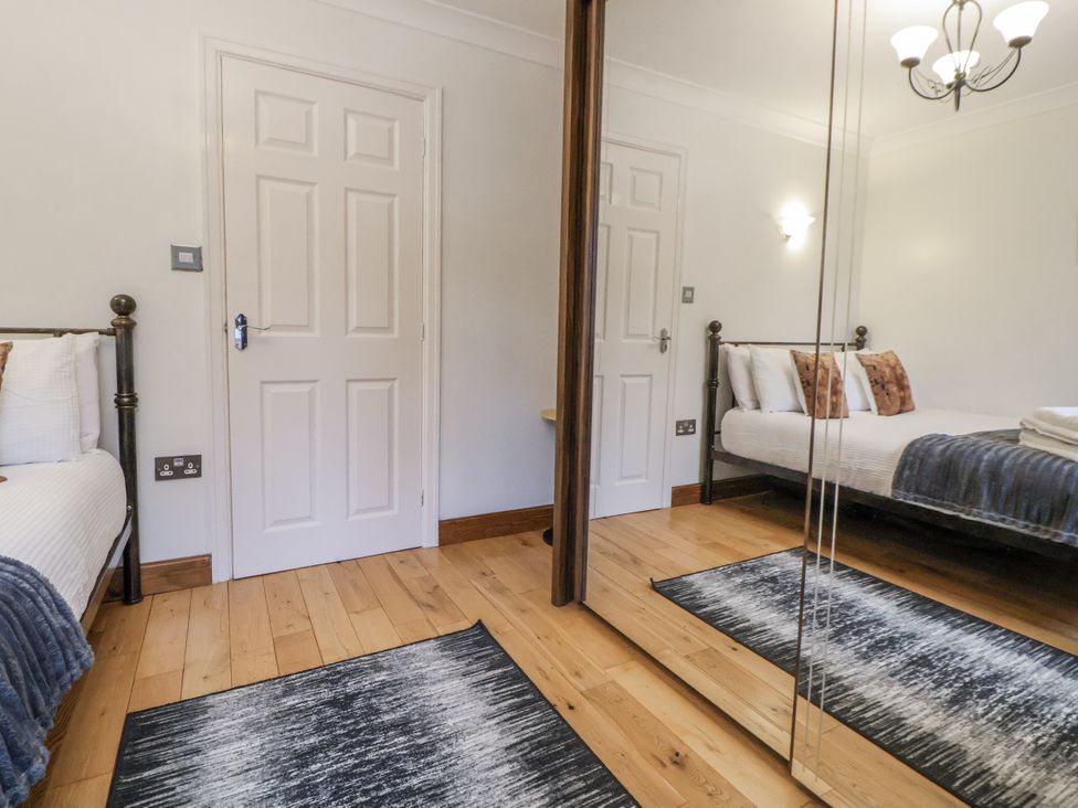 A bedroom with a bed and mirror at Freshwinds in Market Drayton