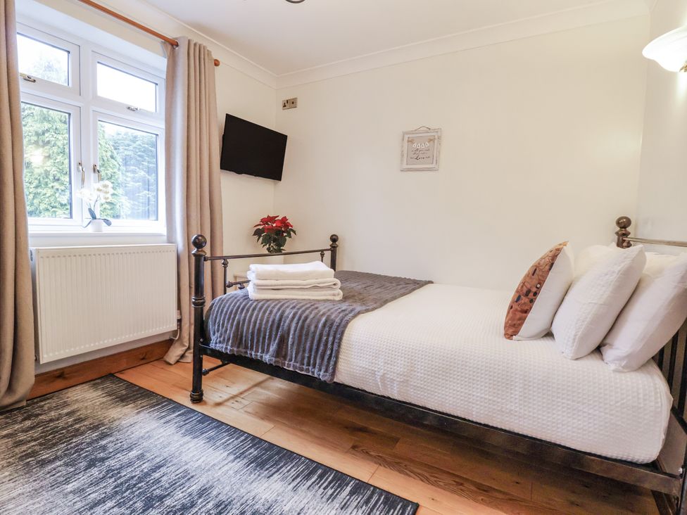 A bedroom with a single bed and a television at Freshwinds Market Drayton