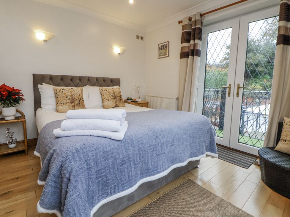 A bedroom with a bed and side table at Freshwinds in Market Drayton