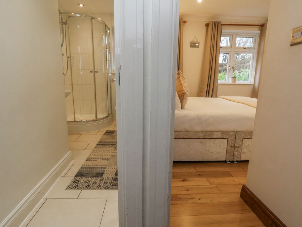A bathroom with a shower and adjoining bedroom at Freshwinds in Market Drayton