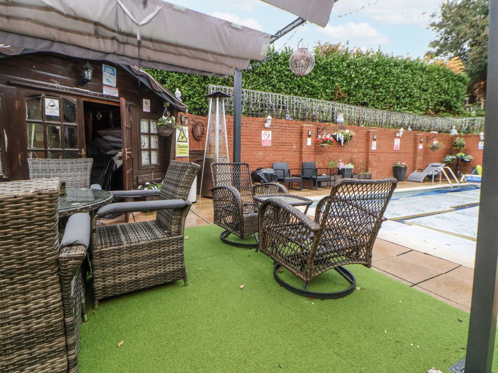 An outdoor space with a pool and seating area at Freshwinds, Market Drayton