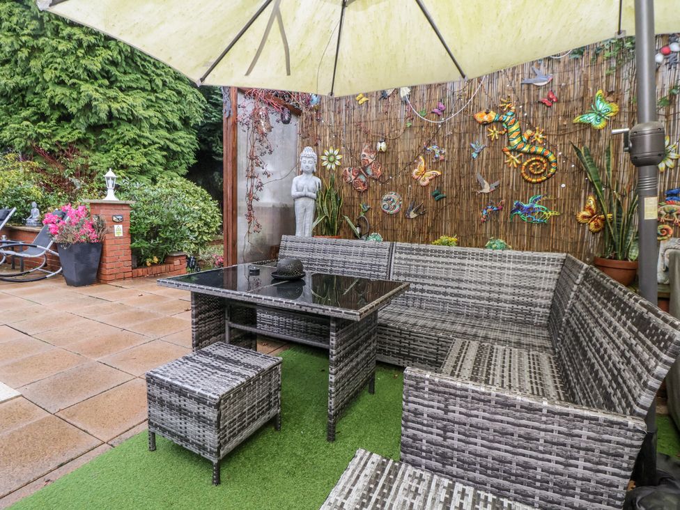 A garden with outdoor furniture and decorative elements at Freshwinds in Market Drayton