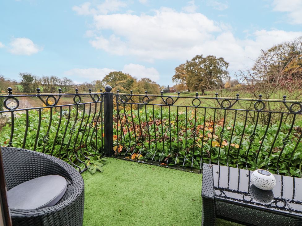 An outdoor space with a chair and table on a balcony at Freshwinds in Market Drayton