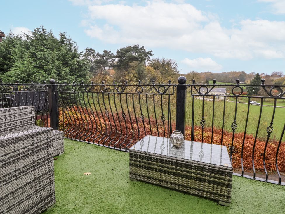 A balcony with a table and couch at Freshwinds in Market Drayton