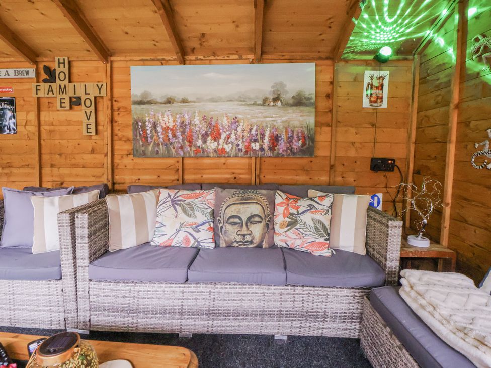 A garden room with a sofa and decorative items at Freshwinds Market Drayton