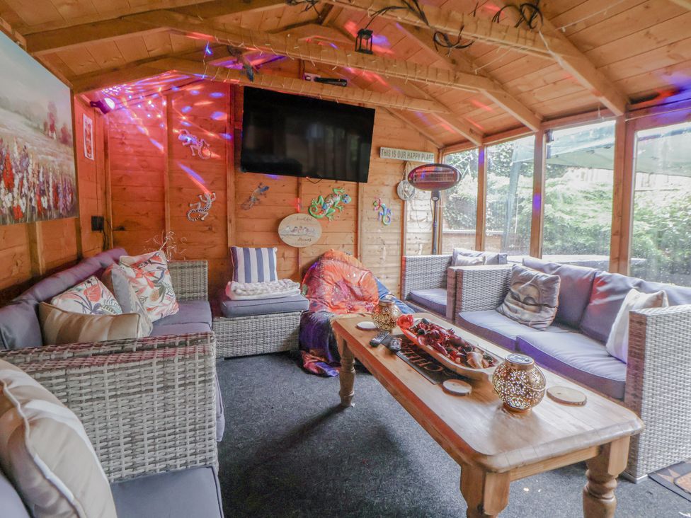 A garden room with sofas and a coffee table at Freshwinds in Market Drayton