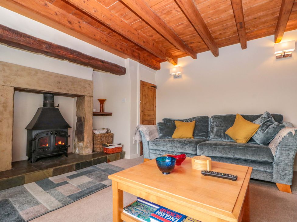 A living room with a sofa and fireplace at Weavers Cottage, Carlton-in-Cleveland near Stokesley