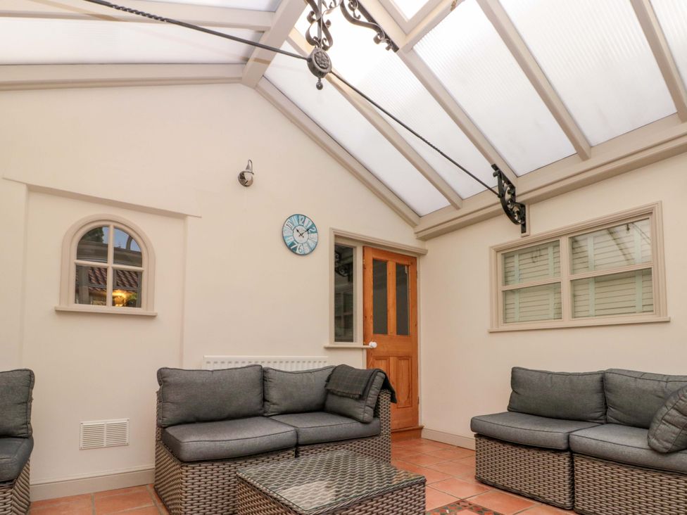 A conservatory with a sofa and coffee table at Weavers Cottage Carlton-in-Cleveland near Stokesley