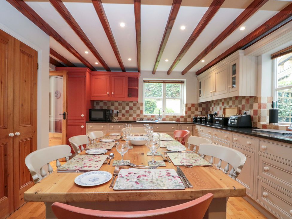 A kitchen with a dining table set for a meal at Weavers Cottage Carlton-in-Cleveland near Stokesley