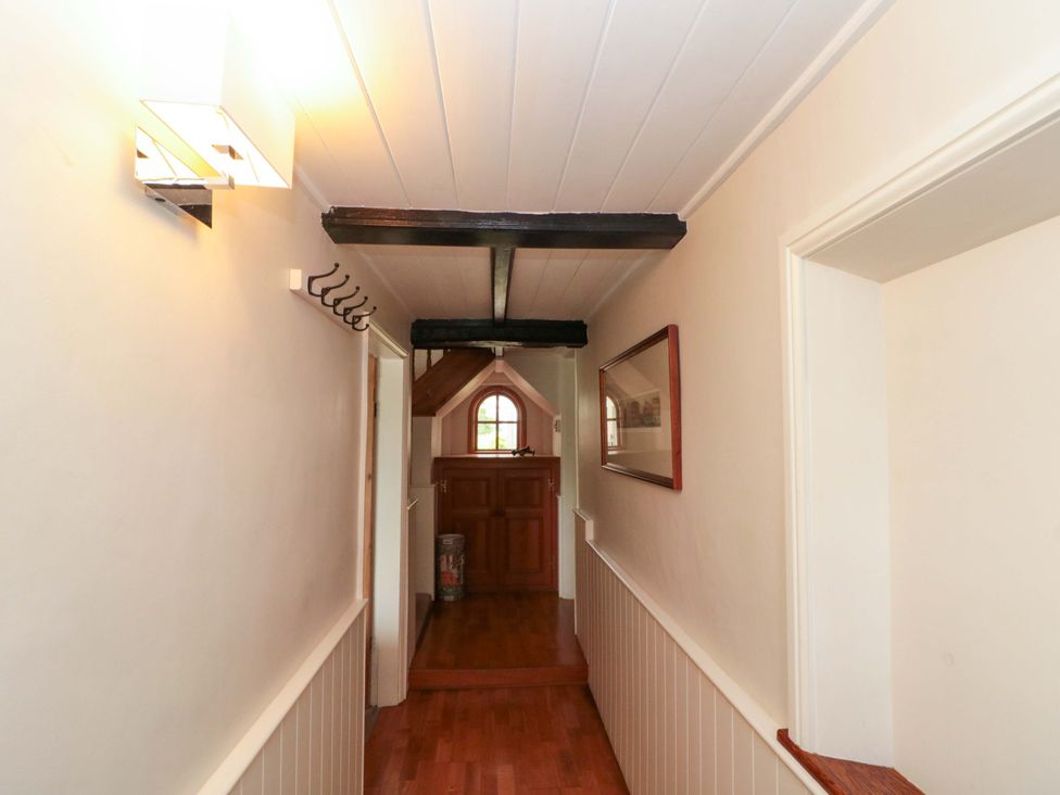 A hallway with wooden beams and coat hooks at Weavers Cottage in Carlton-in-Cleveland near Stokesley