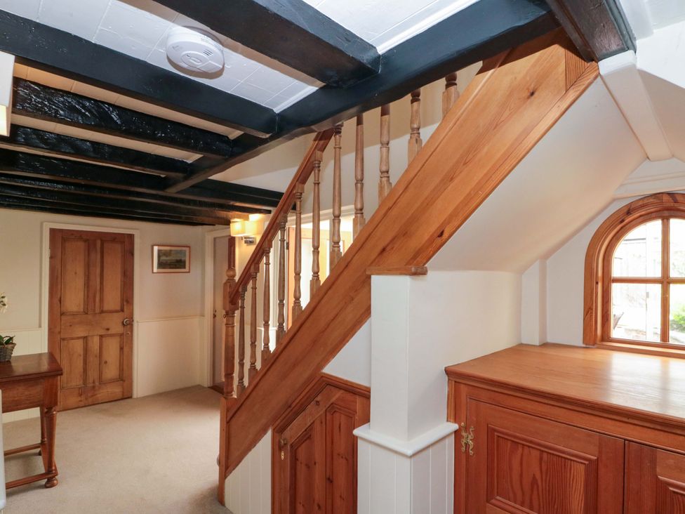 A hallway with stairs and a door at Weavers Cottage in Carlton-in-Cleveland near Stokesley
