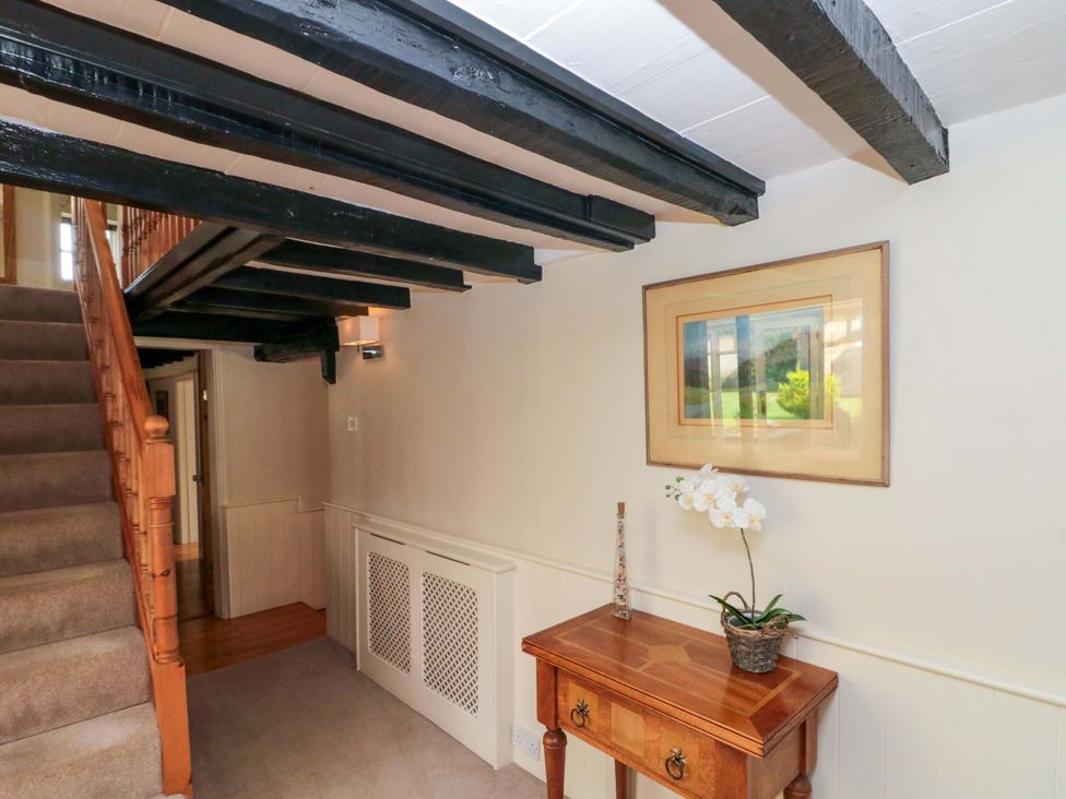 A hallway with stairs and a console table at Weavers Cottage, Carlton-in-Cleveland near Stokesley