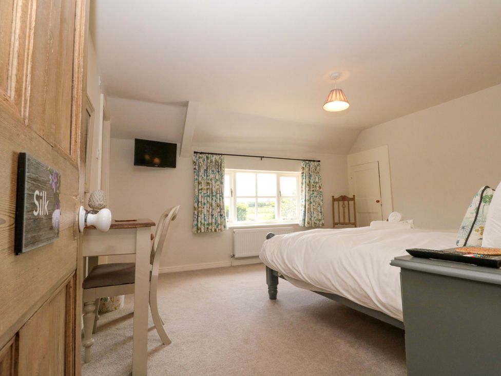 A bedroom with a bed and desk at Weavers Cottage Carlton-in-Cleveland near Stokesley