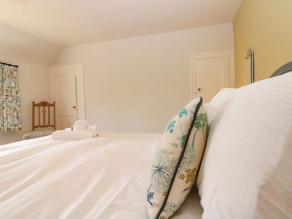 A bedroom with a bed and a chair at Weavers Cottage in Carlton-in-Cleveland near Stokesley