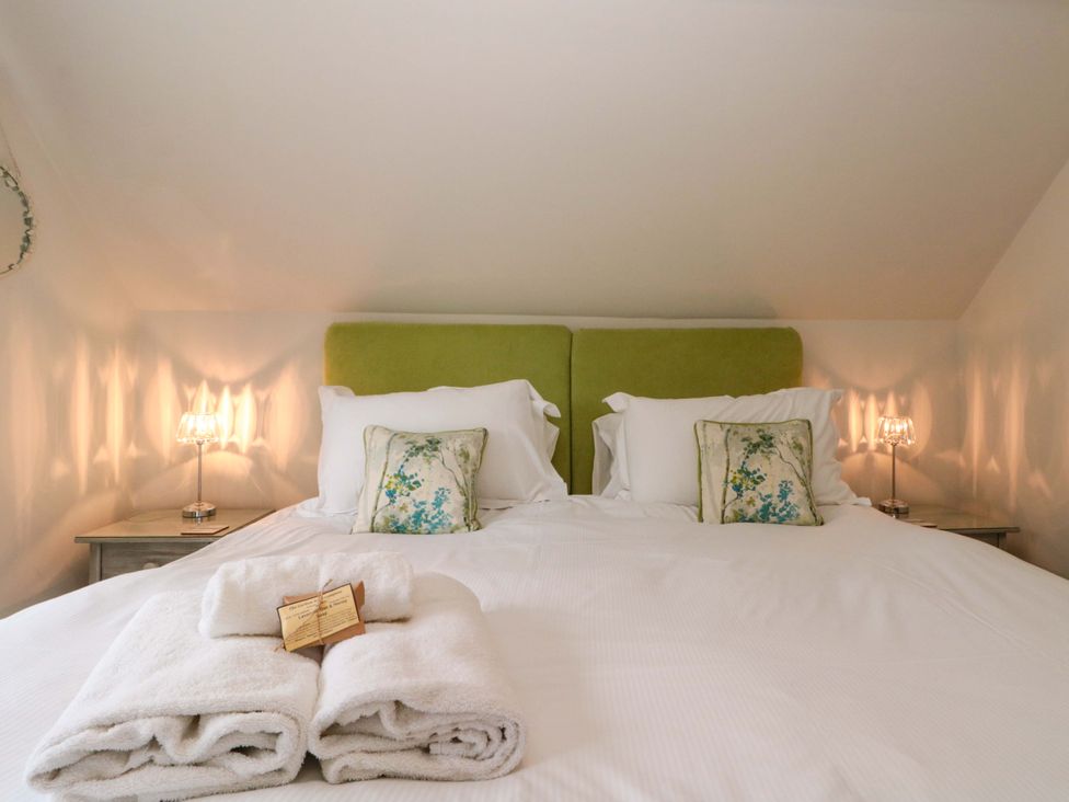 A bedroom with a bed and bedside lamps at Weavers Cottage in Carlton-in-Cleveland near Stokesley