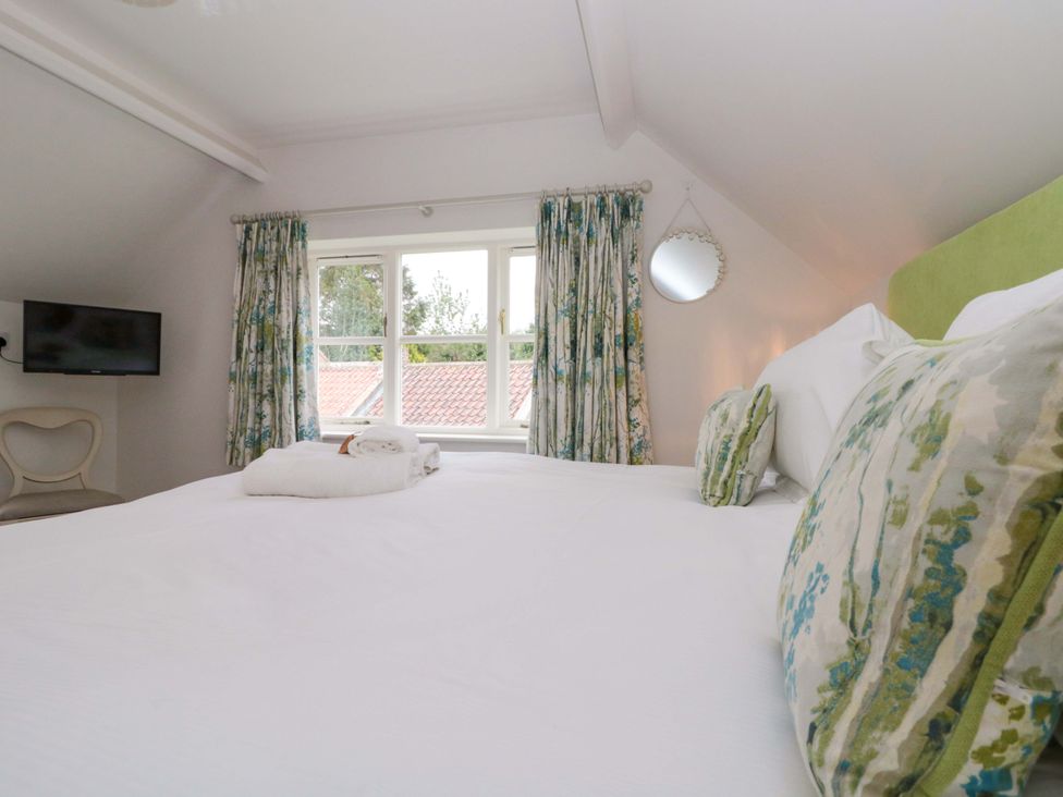 A bedroom with a bed and television at Weavers Cottage Carlton-in-Cleveland near Stokesley