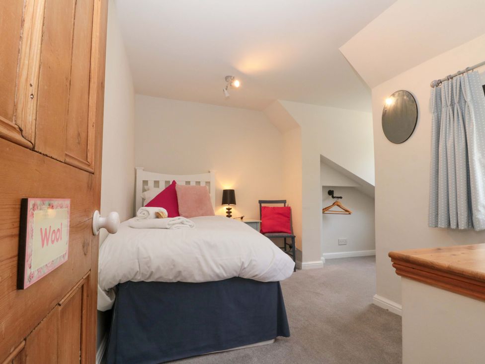 A bedroom with a single bed and a chair at Weavers Cottage in Carlton-in-Cleveland near Stokesley