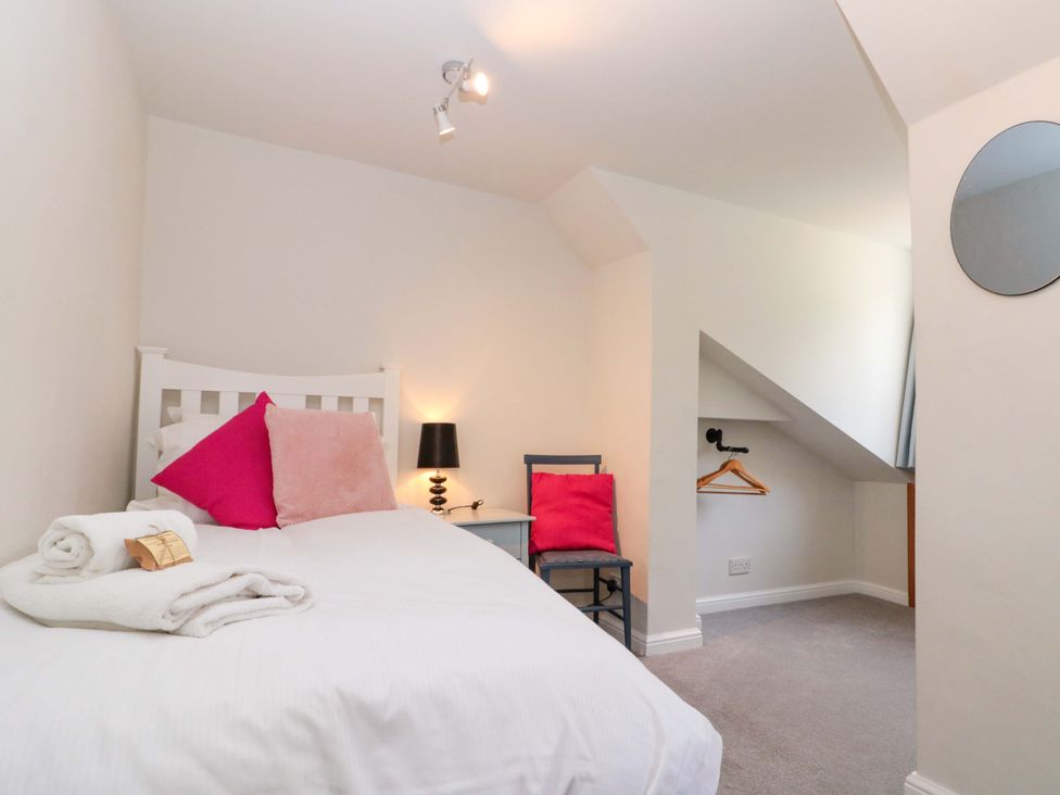 A bedroom with a bed and a chair at Weavers Cottage in Carlton-in-Cleveland near Stokesley