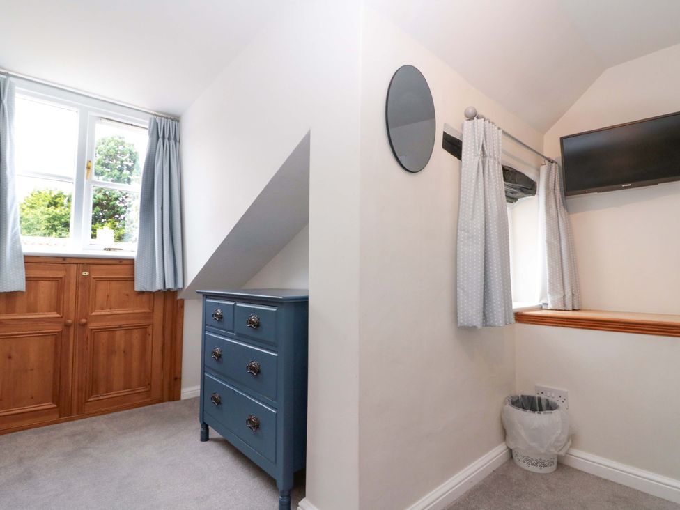 A bedroom with a wardrobe and a small TV at Weavers Cottage, Carlton-in-Cleveland near Stokesley