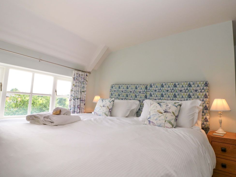 A bedroom with a bed and lamps at Weavers Cottage Carlton-in-Cleveland near Stokesley