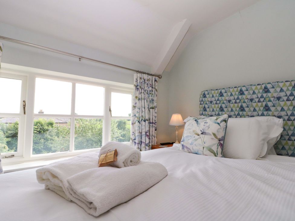 A bedroom with a bed and a window at Weavers Cottage Carlton-in-Cleveland near Stokesley