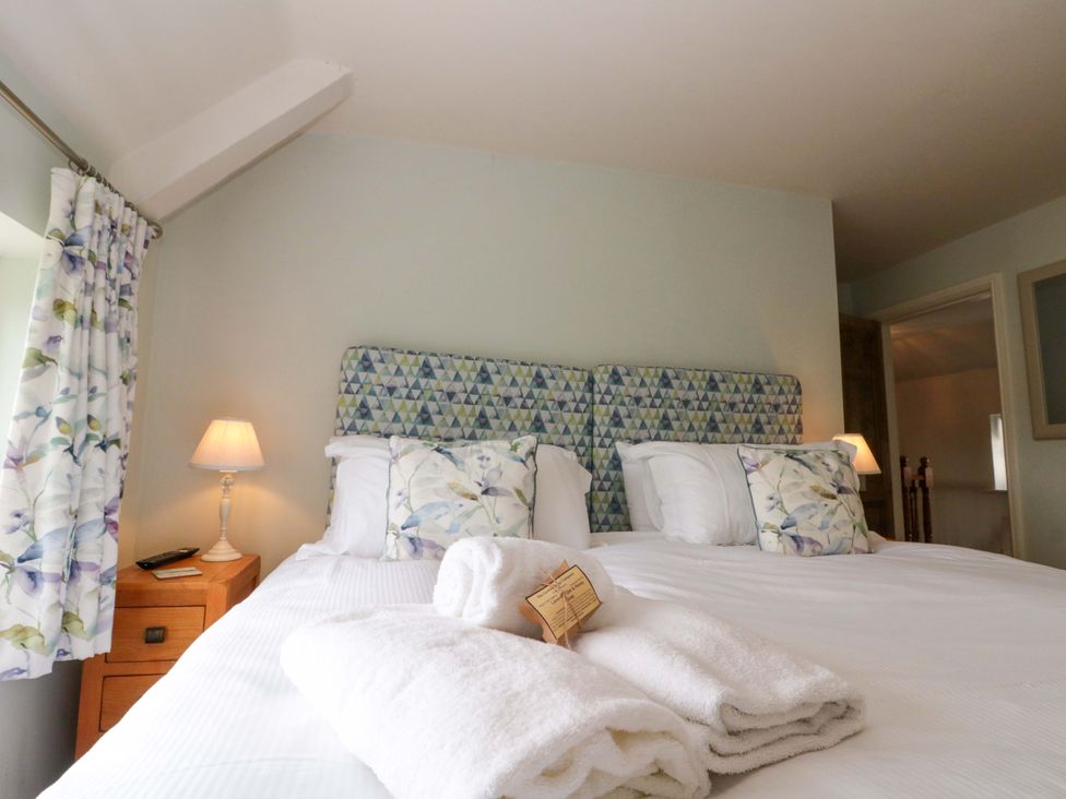 A bedroom with a double bed and lamps at Weavers Cottage Carlton-in-Cleveland near Stokesley