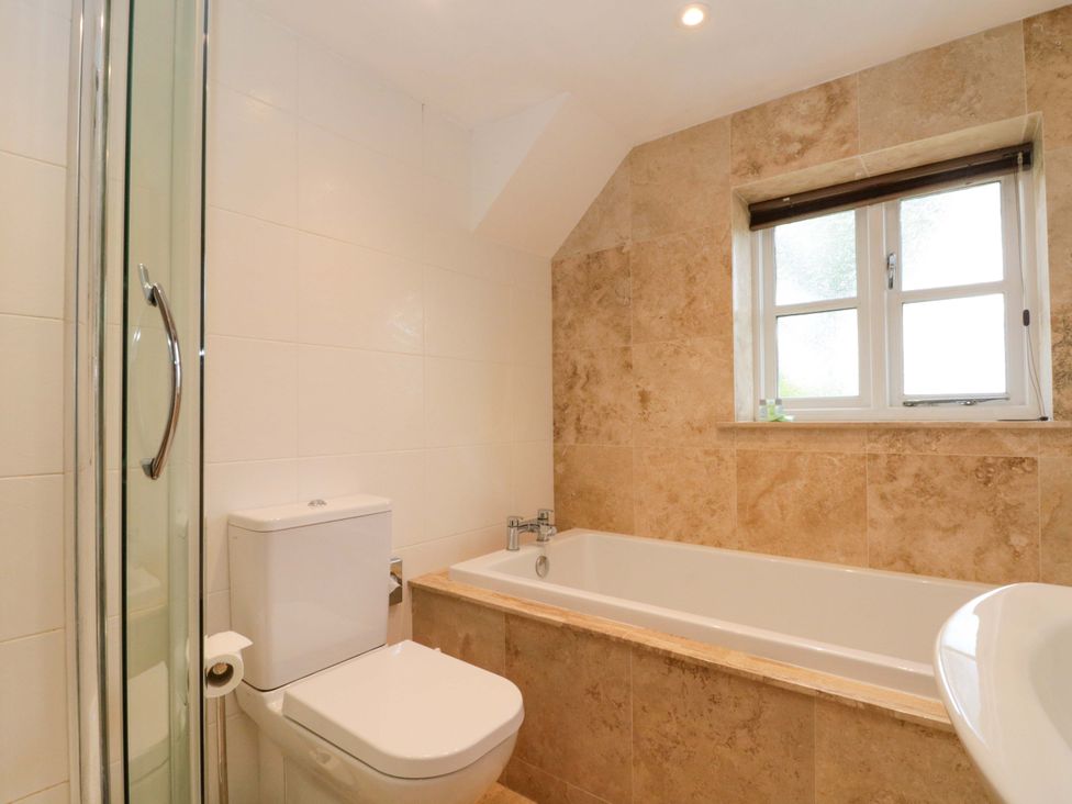 A bathroom featuring a shower, toilet, bathtub, and sink at Weavers Cottage in Carlton-in-Cleveland near Stokesley