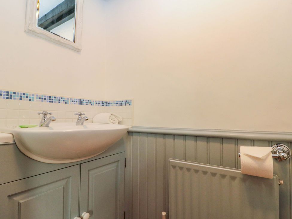 A bathroom with a sink and mirror at Weavers Cottage in Carlton-in-Cleveland near Stokesley