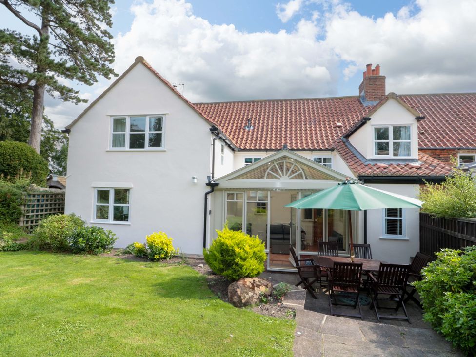 A house with a garden and patio dining area at Weavers Cottage in Carlton-in-Cleveland near Stokesley