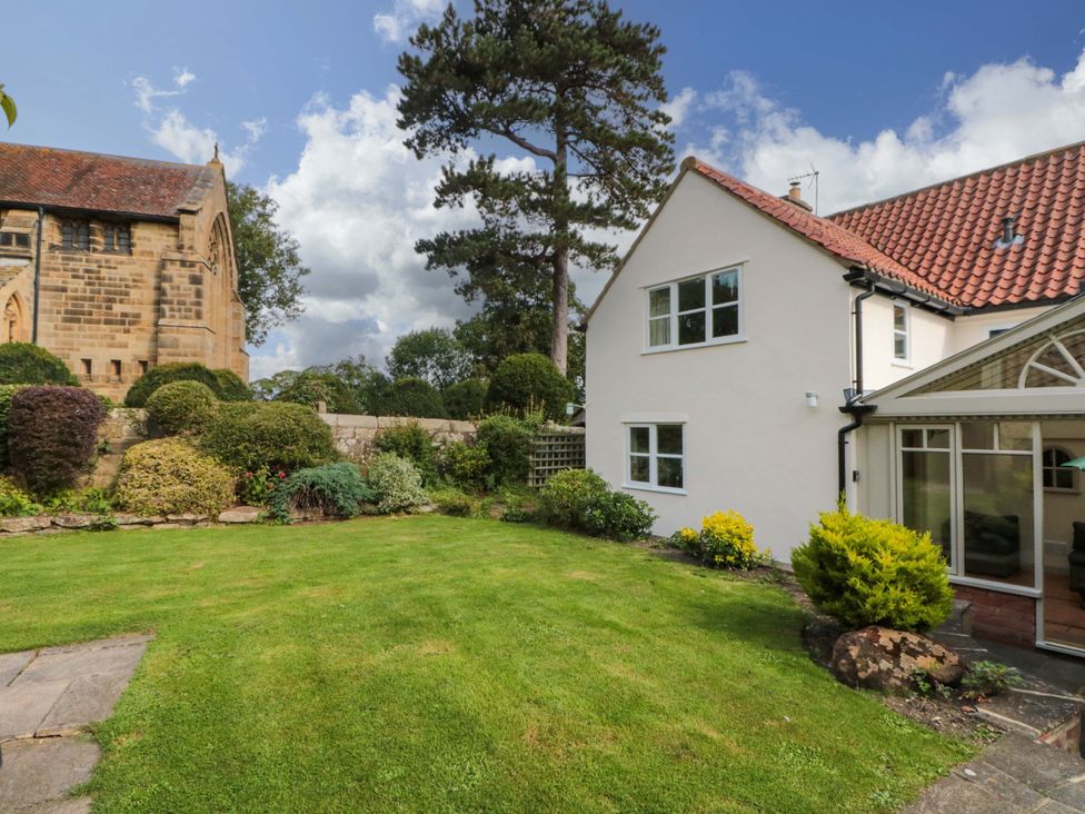 A garden with a house and trees at Weavers Cottage, Carlton-in-Cleveland near Stokesley