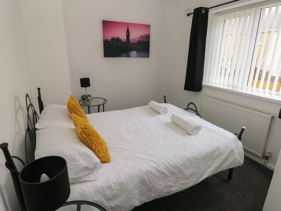 A bedroom with a bed and nightstand at Cwtch Ar Y Mor in Burry Port