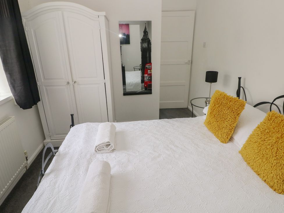A bedroom with a bed and wardrobe at Cwtch Ar Y Mor Burry Port