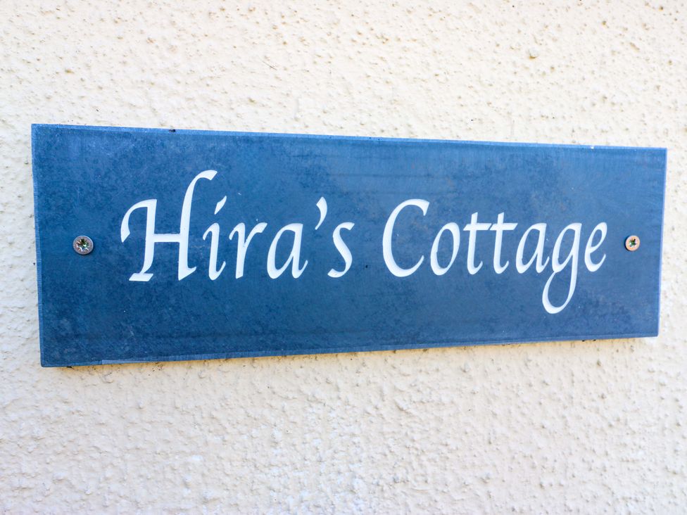 A nameplate displaying Hira's Cottage on a wall