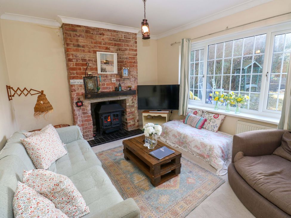 A living room with a fireplace and two sofas at Hira's Cottage