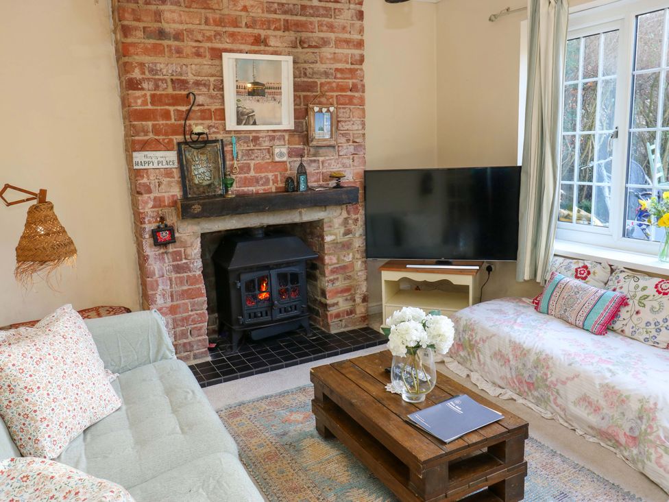 A living room with a sofa and television at Hira's Cottage