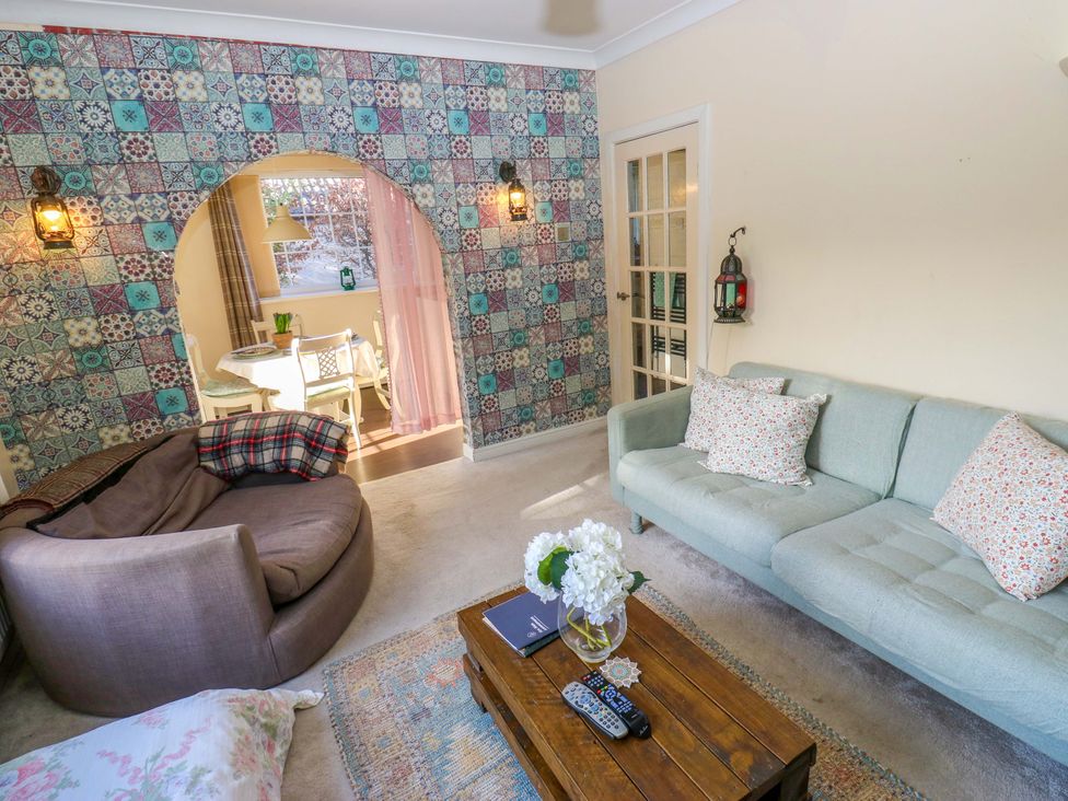 A living room with a sofa and coffee table at Hira's Cottage