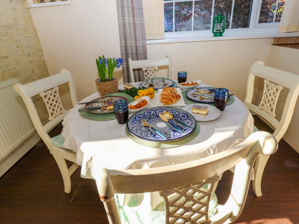 A dining room with a table set for a meal at Hira's Cottage 
